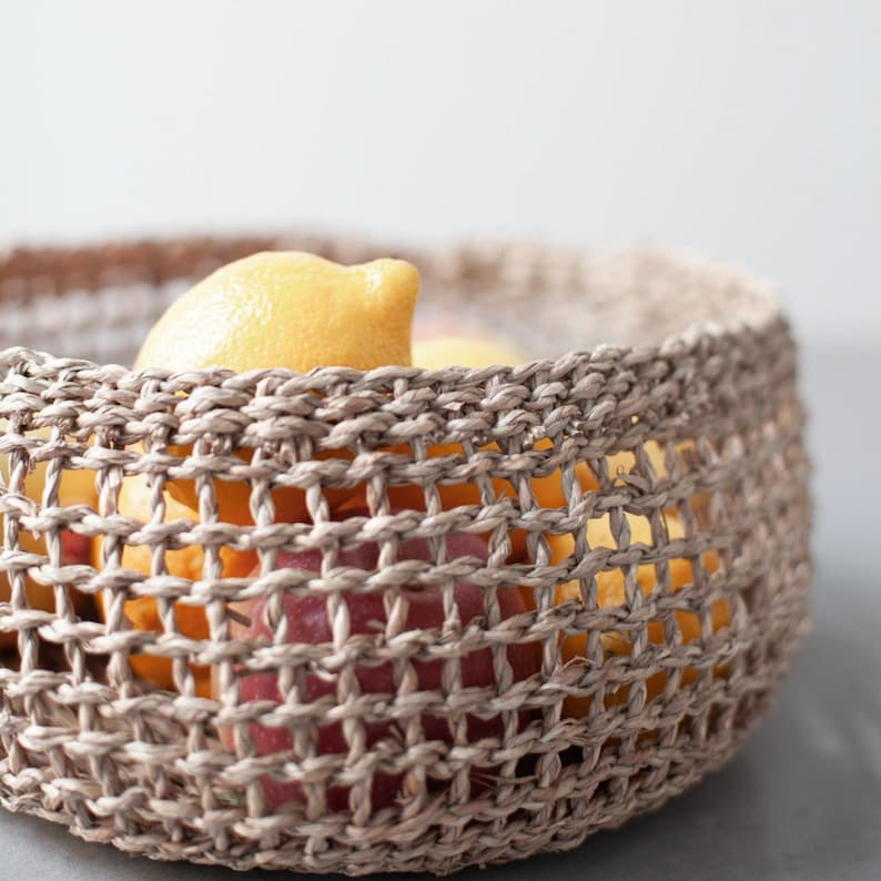 Detailaufnahme des runden Seegras Korbs Bola, gefüllt mit frischen Zitronen