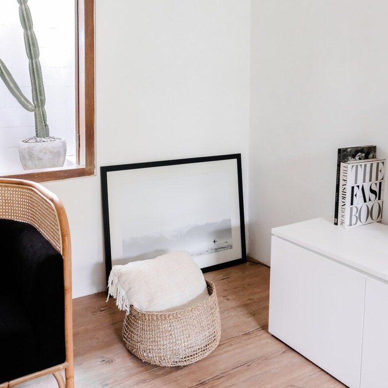 Großer runder Seegras Korb Bola im Wohnzimmer, dekorativ mit Kissen gefüllt, neben Sofa platziert