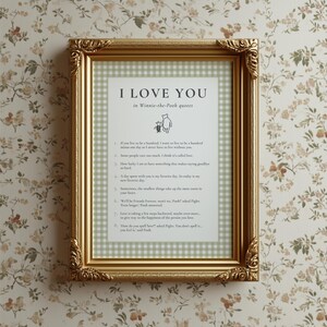 K&ouml;nnte beinhalten: Goldgerahmter Druck mit dem Text "I LOVE YOU" und Zitaten von Winnie Puuh. Der Druck hat einen gr&uuml;n-wei&szlig; karierten Hintergrund. Der Rahmen hat verzierte Ecken und wird vor einer floralen Tapete pr&auml;sentiert.
