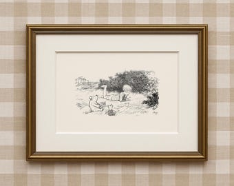 May include: Framed black and white illustration of Winnie the Pooh, Piglet, and Christopher Robin in a grassy field. The artwork shows Pooh and Piglet seated, with Christopher Robin lying down. The frame is gold-coloured.