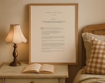 May include: A framed wall art print featuring the text of the first chapter of Winnie-the-Pooh by A.A. Milne. The print is displayed in a light wood frame with a cream-colored background and black serif typography, centered on a wall.