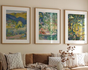 May include: Three framed landscape paintings with a brown couch, throw pillows, and a wooden coffee table in front of them. The paintings are all in a similar style, with a pointillist technique and a focus on trees and foliage.