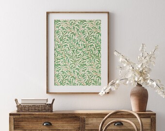 May include: A framed print of a green and white floral pattern hangs above a wooden dresser with two drawers. A vase with white flowers sits on the dresser.