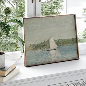 May include: A framed watercolor painting of a sailboat on a body of water with a green hillside in the background.
