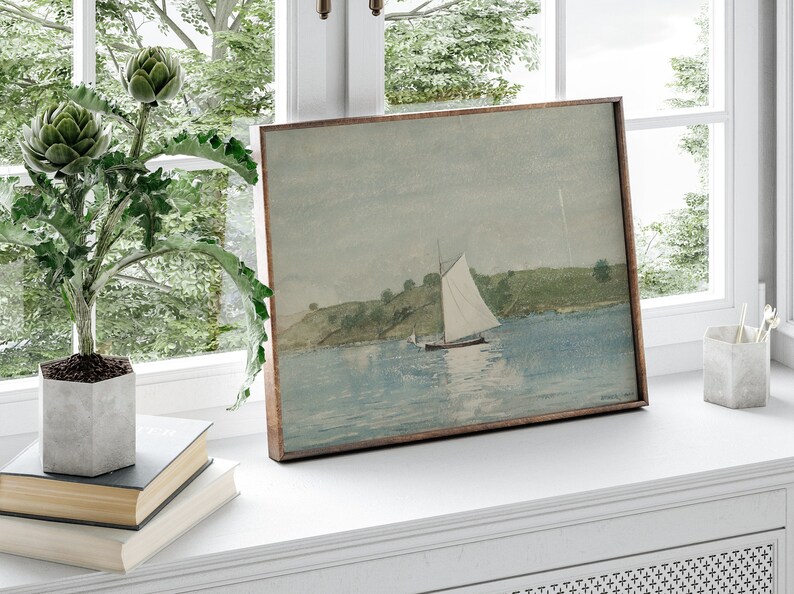 May include: A framed watercolor painting of a sailboat on a body of water with a green hillside in the background.