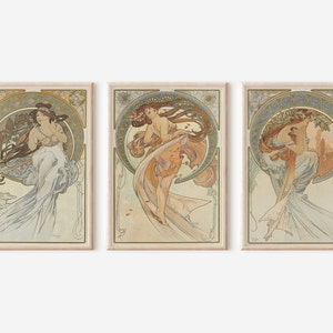 Puede incluir: Tres impresiones de arte enmarcadas que presentan ilustraciones de estilo Art Nouveau de mujeres con vestidos fluidos. Las impresiones est&aacute;n sobre un fondo beige claro.