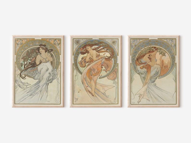 Puede incluir: Tres impresiones de arte enmarcadas que presentan ilustraciones de estilo Art Nouveau de mujeres con vestidos fluidos. Las impresiones est&aacute;n sobre un fondo beige claro.