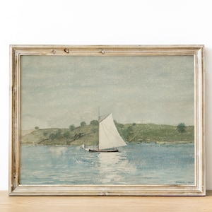 May include: A framed watercolor painting of a sailboat on a body of water with a green grassy hill in the background.