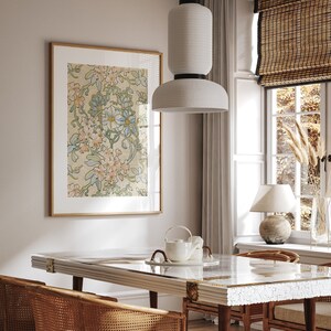 Puede incluir: Una impresi&oacute;n art&iacute;stica floral enmarcada con un fondo beige claro y flores de colores pastel en un comedor. La habitaci&oacute;n cuenta con una mesa de m&aacute;rmol blanco, sillas de rat&aacute;n y una l&aacute;mpara colgante blanca. Tambi&eacute;n se ve una ventana con una persiana de bamb&uacute; y una l&aacute;mpara de mesa.