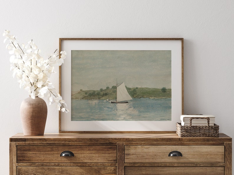 May include: A framed watercolor painting of a sailboat on a calm body of water with a small island in the background.