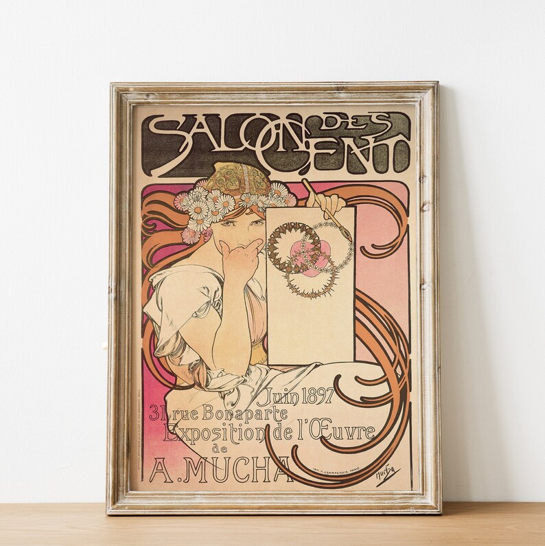 May include: A vintage poster advertising the Salon des Cent, an art exhibition in Paris, France. The poster features a woman in a white dress and a floral crown, holding a blank canvas. The text on the poster reads "Salon des Cent, Juin 1897, 31 rue Bonaparte, Exposition de l'&OElig;uvre de A. Mucha."