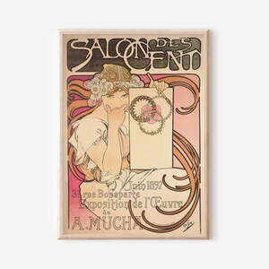May include: A vintage poster advertising an art exhibition by Alphonse Mucha. The poster features a woman with flowing red hair wearing a crown of flowers, holding a paintbrush and a blank canvas. The text on the poster reads "Salon des Cent, Juin 1897, 31 rue Bonaparte, Exposition de l'&OElig;uvre de A. Mucha."