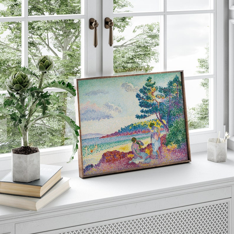 May include: A framed painting of a seascape with two figures in the foreground. The painting is done in a pointillist style with a bright color palette. The figures are wearing white clothing and are standing on a rocky shore. The sea is a vibrant blue and the sky is a soft blue with pink and purple clouds.