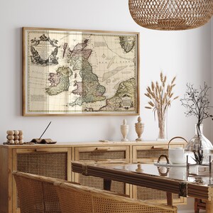 Può includere: Una mappa vintage delle Isole Britanniche incorniciata in una cornice di legno chiaro, appesa sopra un armadio in legno con ante in rattan intrecciato. La mappa è in tonalità di marrone, verde e rosso, con testo in caratteri neri. L'armadio ha due ante ed è decorato con ferramenta in ottone.