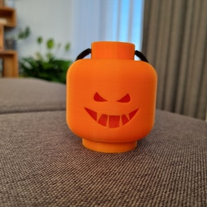 May include: Orange plastic Halloween jack-o'-lantern shaped ornament with a black string for hanging.