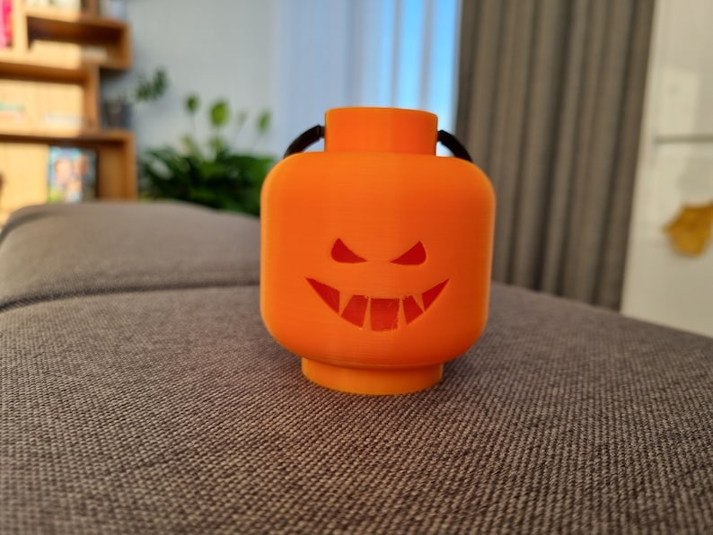 May include: Orange plastic Halloween jack-o'-lantern shaped ornament with a black string for hanging.