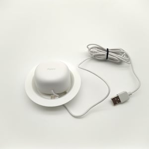 May include: A white charging station with a white charging cable. The charging station has a round base and a round top with the word "Aqara" printed on it.