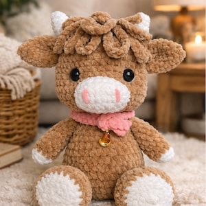 May include: A handmade, plush brown cow with white accents, a pink scarf, and a gold bell. The stuffed animal has large black eyes and is sitting on a white rug. The cow's horns and hooves are white. A cozy, decorative item.