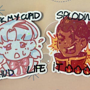 May include: Two holographic stickers featuring anime-style characters. The left sticker shows a light blue character with the text F*CK MY CUPID CHUD LIFE. The right sticker shows a brown-skinned character with the text SPLODING IT with fire icons.