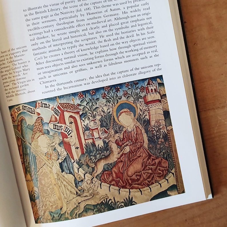 May include: A detailed image of a medieval tapestry depicting a religious scene. The tapestry features figures, architectural elements, and text, with a color palette of reds, blues, and creams. The text includes the words "Mirna doma" and "plena domus".