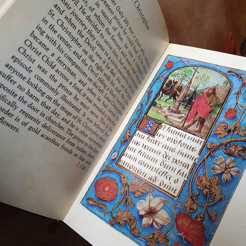 Puede incluir: Un libro abierto con una ilustraci&oacute;n detallada e iluminada. La obra de arte presenta una escena con figuras, una cruz y texto en un marco decorativo con motivos florales y foliares en azul, rojo y dorado. El texto est&aacute; en escritura g&oacute;tica.