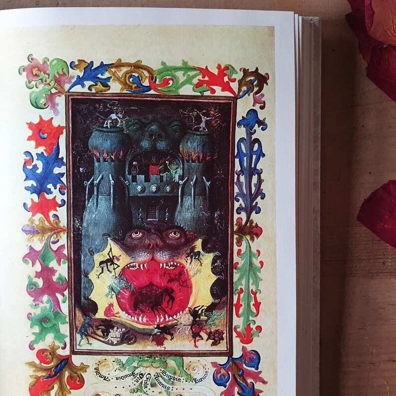 Może przedstawiać: Otwarta książka prezentuje średniowieczną ilustrację o mrocznym, fantastycznym motywie. Grafika przedstawia zamek, potworne postacie i żywą, ozdobną obw&oacute;dkę w kolorach czerwonym, niebieskim i zielonym. Obraz ma estetykę vintage.