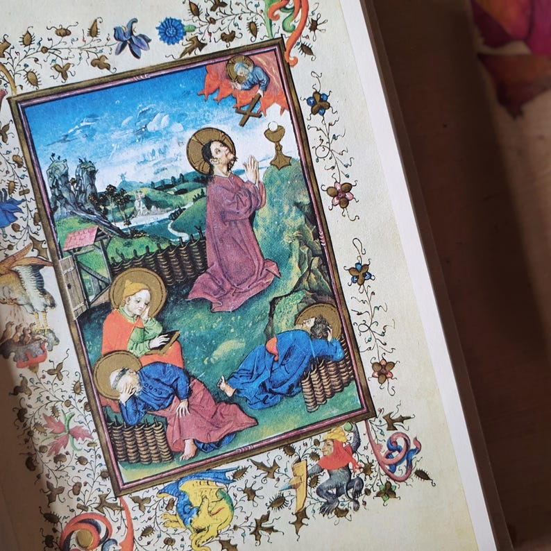 Może przedstawiać: Strona ze średniowiecznego iluminowanego manuskryptu. Grafika przedstawia scenę religijną z postaciami w szatach, osadzoną na tle krajobrazu z błękitnym niebem. Obramowanie zdobią motywy kwiatowe i liściaste w r&oacute;żnych kolorach.