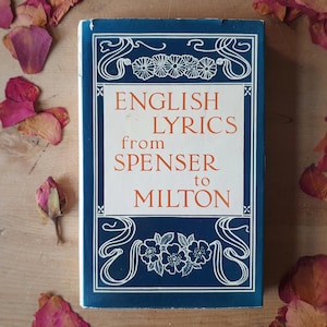 以下が含まれることがあります： 青い表紙と白い花柄とスクロールデザインの「ENGLISH LYRICS from SPENSER to MILTON」というタイトルのヴィンテージ本。テキストはオレンジ色です。乾燥したバラの花びらとつぼみが、木の表面にある本の周りに散らばっています。