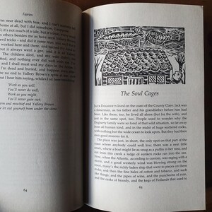 May include: Open book with text and a black and white illustration of a house with fish above it. The text reads "The Soul Cages" and is from a book about fairies.