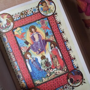 Może przedstawiać: Szczeg&oacute;łowa ilustracja z średniowiecznego manuskryptu. Grafika przedstawia postacie religijne w żywych kolorach, w tym niebieskim, czerwonym i fioletowym, w dekoracyjnej czerwonej obw&oacute;dce. Okrągłe medaliony z postaciami zwierząt i tekstem otaczają centralny obraz.