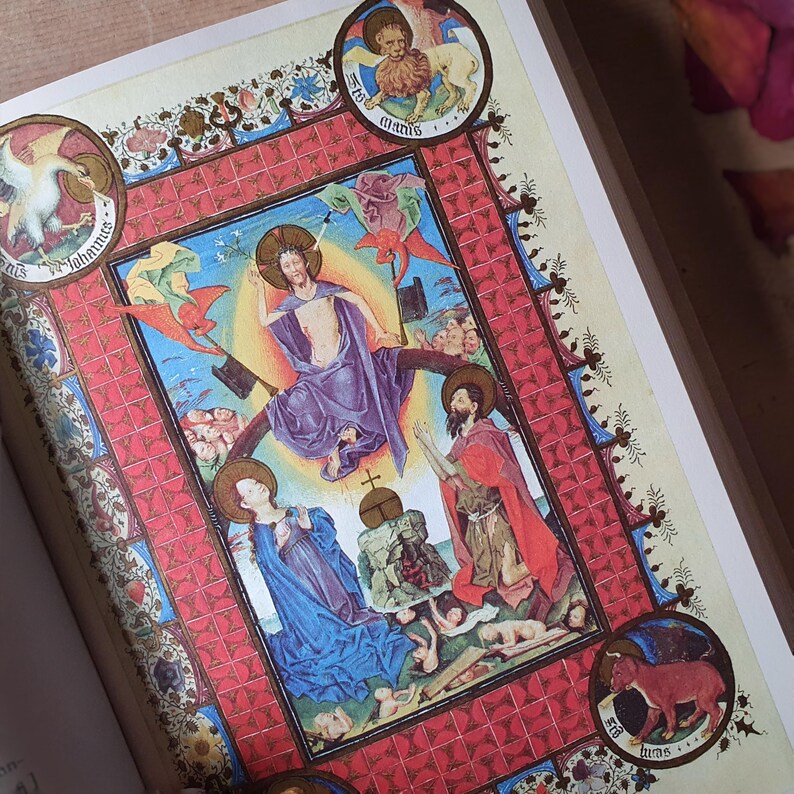 Może przedstawiać: Szczeg&oacute;łowa ilustracja z średniowiecznego manuskryptu. Grafika przedstawia postacie religijne w żywych kolorach, w tym niebieskim, czerwonym i fioletowym, w dekoracyjnej czerwonej obw&oacute;dce. Okrągłe medaliony z postaciami zwierząt i tekstem otaczają centralny obraz.