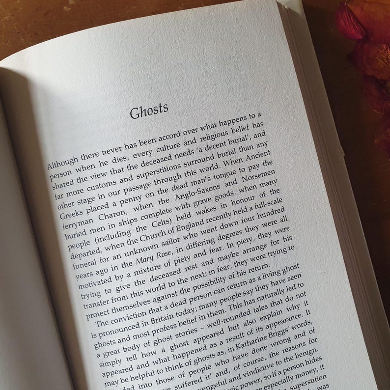 May include: Open book with the title "Ghosts" at the top of the page. The text discusses cultural beliefs about death, burial customs, and ghost stories.