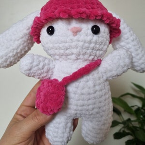 Lapin amigurumi au crochet en laine chenille blanc avec un chapeau rose et un sac rose de près
