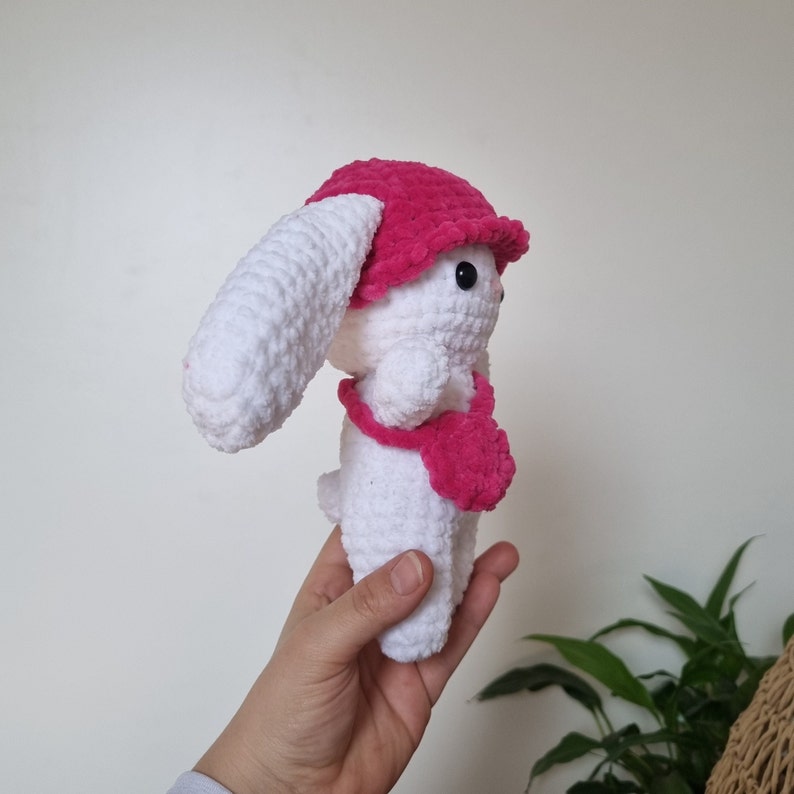 Lapin amigurumi au crochet en laine chenille blanc avec un chapeau rose et un sac rose de côté