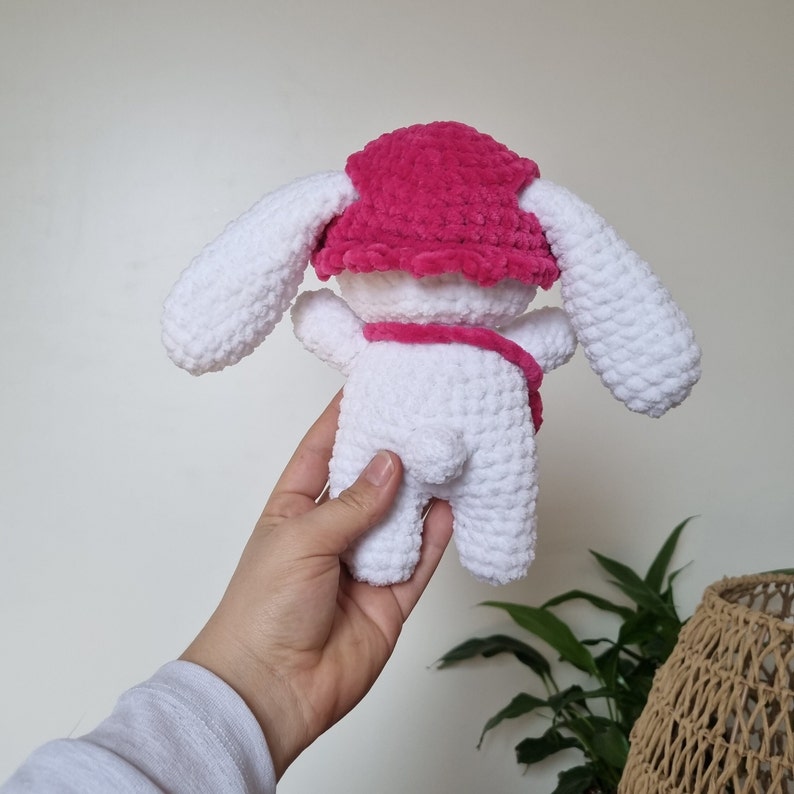 Lapin amigurumi au crochet en laine chenille blanc avec un chapeau rose et un sac rose de dos
