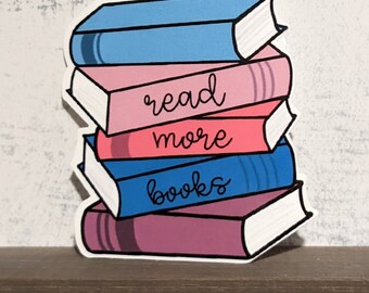 May include: A stack of colorful books with the text "read more books" on the front. The books are blue, pink, and purple.