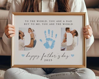 Puede incluir: Una impresión enmarcada blanca con una huella de mano azul y dos fotos de un padre y un hijo. El texto dice "Para el mundo, eres un padre, pero para mí, eres el mundo. Feliz Día del Padre 2025."