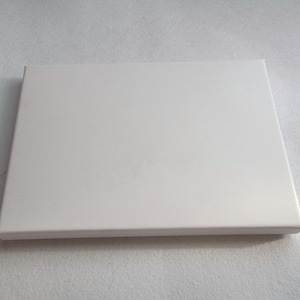 May include: A white rectangular box with a smooth, matt finish.