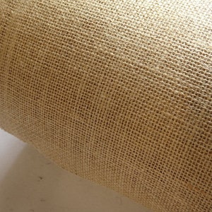 May include: Close-up of a roll of natural brown hessian fabric with a woven texture.
