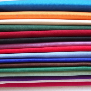 May include: A stack of fabric swatches in various colours, including blue, orange, white, green, red, purple, brown, and grey.