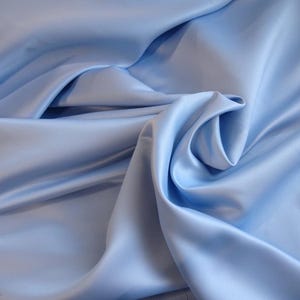 May include: A smooth, light blue satin fabric with a soft, flowing drape.