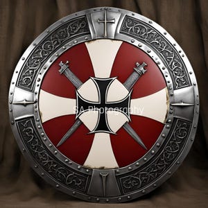 Puede incluir: Un escudo redondo de color plateado con una cruz negra y dos espadas. El escudo tiene un fondo rojo y blanco con un borde decorativo.