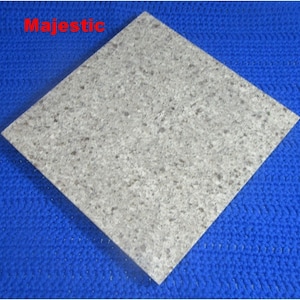 May include: A square, light gray tile with a speckled pattern. The tile is set at a diagonal angle against a blue textured background. The word "Majestic" is written in red in the upper left corner.