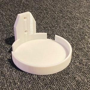 Op de afbeelding: Witte plastic wandbeugel met een rond plankje voor een slim apparaat.