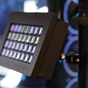 May include: A black light panel with a grid of white LED lights. The panel is mounted on a black stand.
