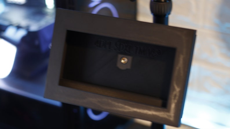 May include: A black metal frame with a small rectangular opening. The frame has a screw in the center and the text "HDR SUN TIME" is visible.