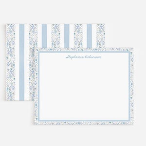 May include: A rectangular stationery card and matching envelope featuring a light blue and white striped pattern with delicate blue floral accents. The card has a white center, a blue border, and the name Stephanie Robinson printed in blue.