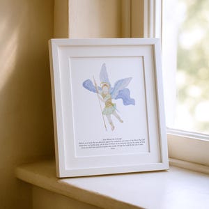 May include: A framed watercolor print of Archangel Michael, depicted with blue wings and a spear. The artwork is in a white frame and includes text at the bottom. The print is displayed on a white windowsill.