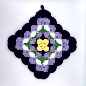 May include: A square, handmade crochet potholder in a floral pattern. The potholder features a central yellow flower, surrounded by white, green, and lavender squares, with a dark blue scalloped border. A loop is attached for hanging.