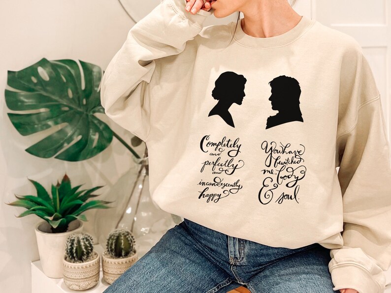Cream colored sweat shirt with classic cameos and quotes from pride and prejudice.